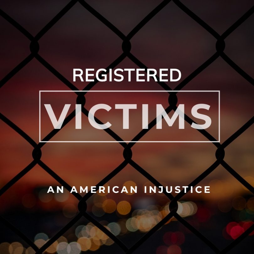 Words on a backdrop of a chain link fence: "Registered Victims: An American Injustice"