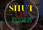 A black box with yellow red and green lettering spelling "Shut Up Fools" in side a bubble.