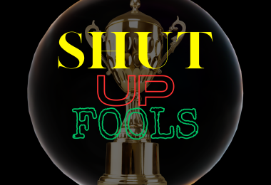 A Black square with Yellow red and green lettering spelling out Shut Up Fools in front of a gold trophy surrounded by a bubble.